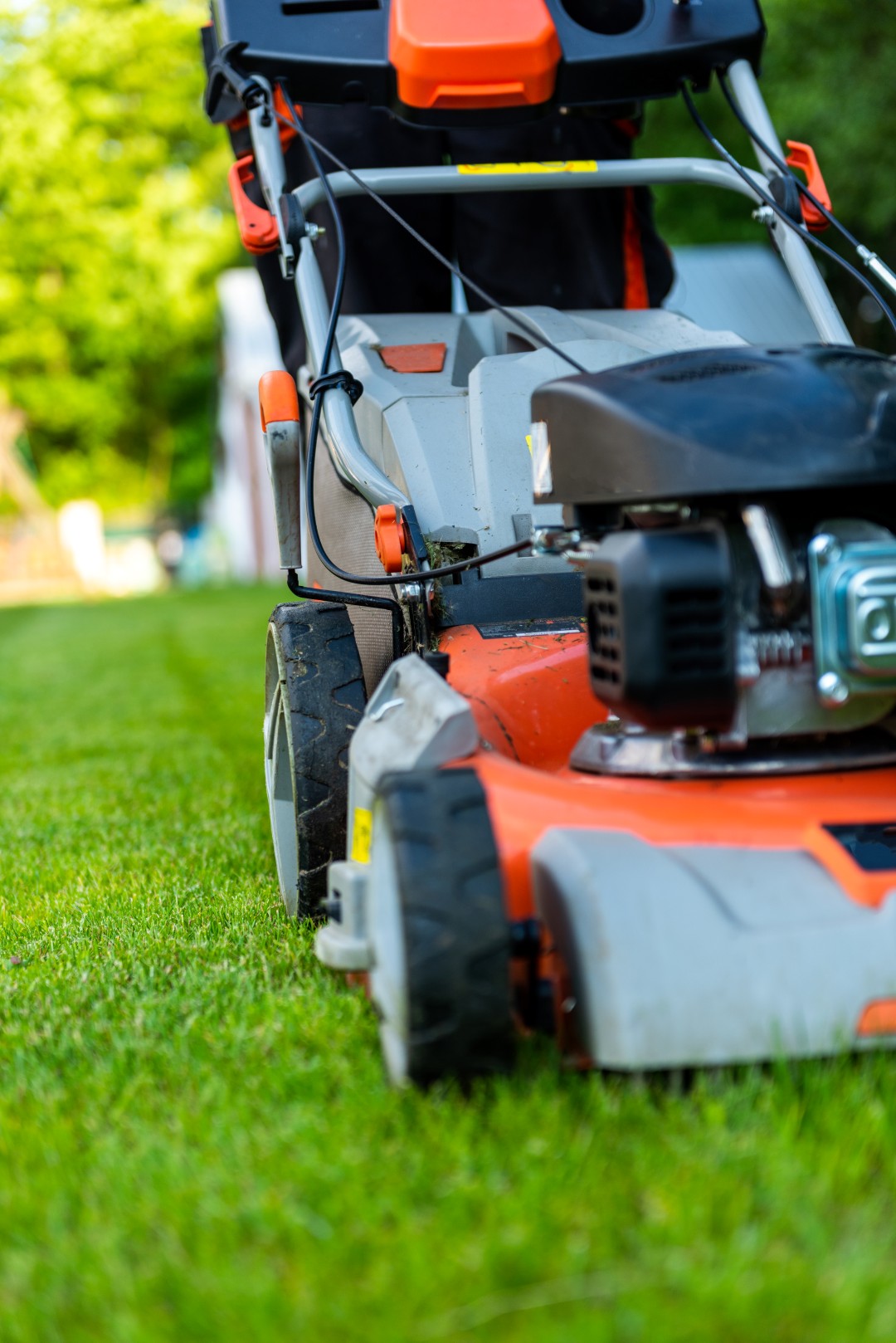man mowing a lawn with a gas powered lawn mower